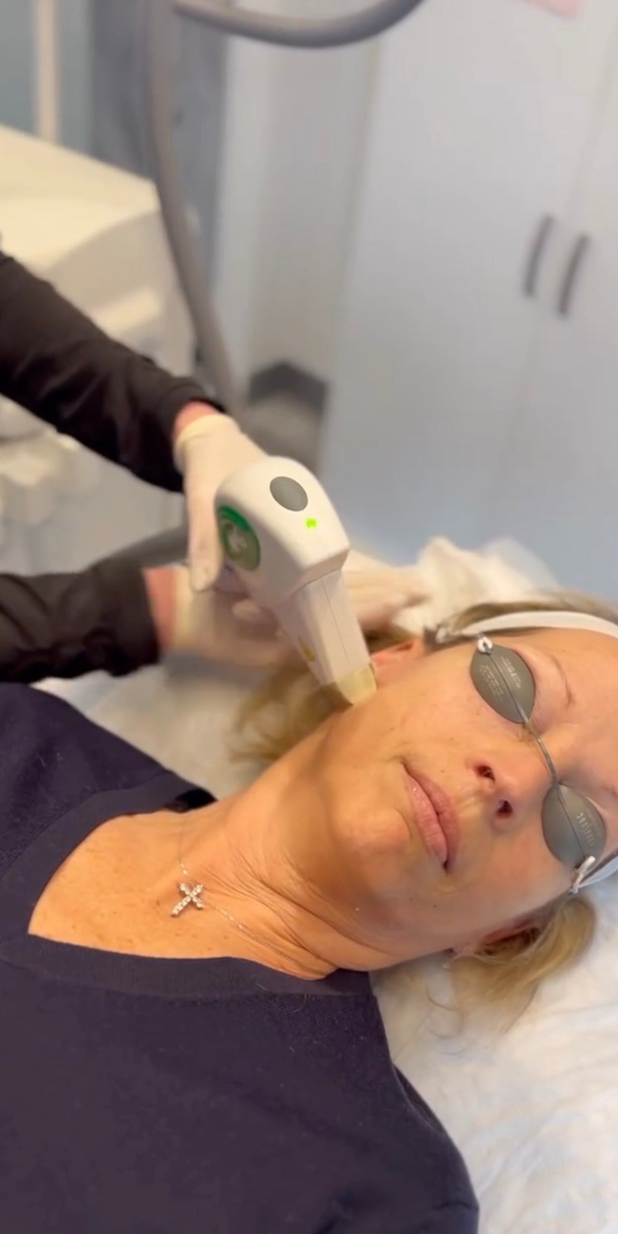 Woman receiving a facial treatment with a device on her face.