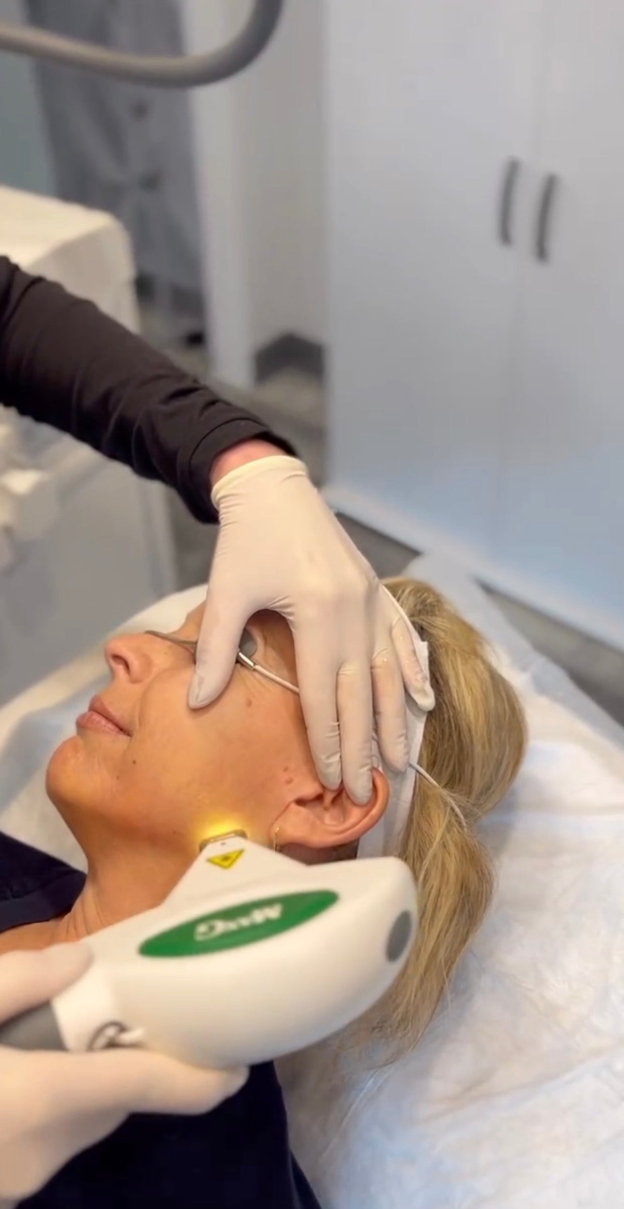Person receiving a IPL Laser facial treatment in a clinical setting.