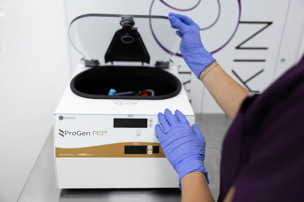 Person wearing gloves interacting with a ProGen NMR machine in a laboratory setting. PRP Treatment Radiance at Fluhme