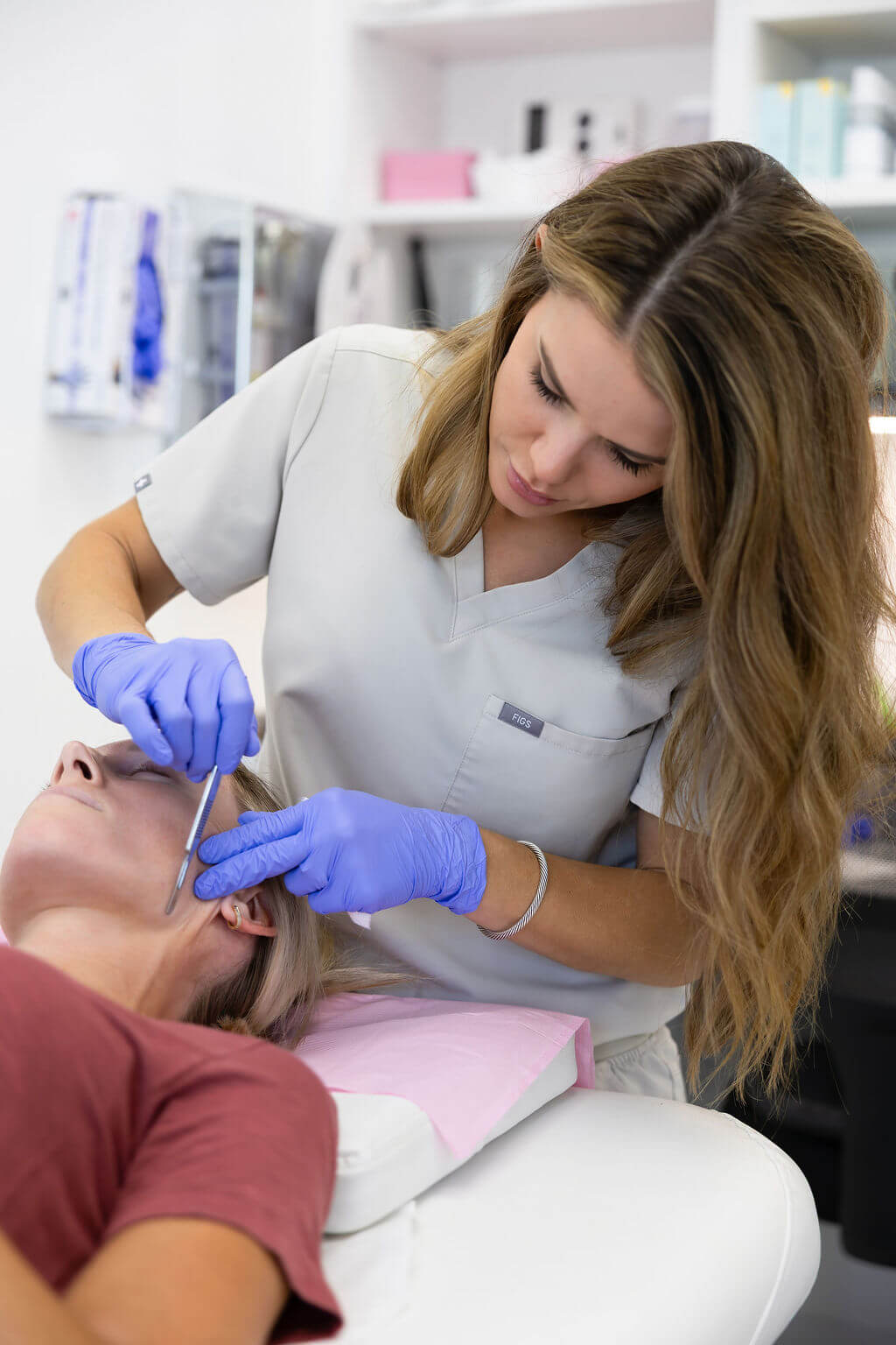 aesthetic professional performing dermaplane treatment in a clinical setting